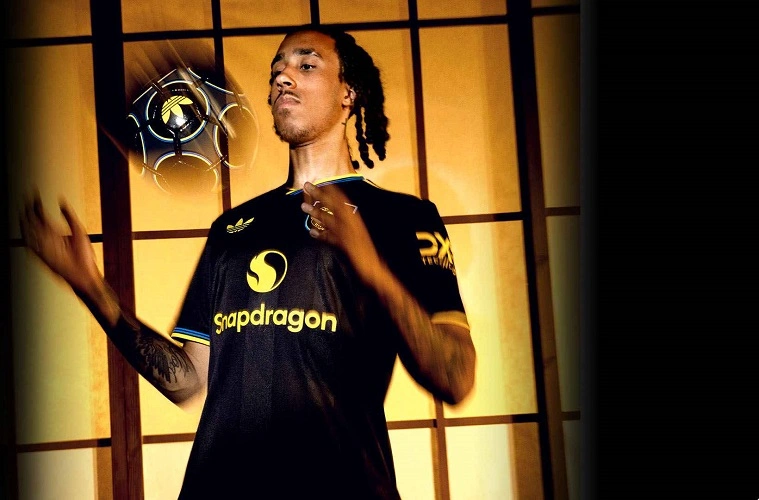 Manchester United Third Kit 25/26 in black with yellow and blue details and Trefoil logo.