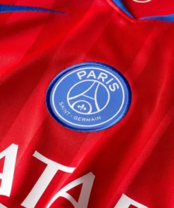 Close-up of Paris Saint-Germain badge on the Nike PSG Red Third Kit 25/26.