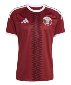 Adidas Qatar Home Kit 2026, front view, maroon base with white details, crewneck, short sleeves.
