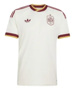 Adidas Spain Away Kit 2026, front view, off-white with manuscript pattern, gold and burgundy cuffs, short sleeves.