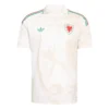 Adidas Wales Away Kit 2026, front view, cream base with stylized dragon pattern, polo collar, short sleeves.
