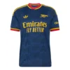 Front view of the adidas Arsenal 26/27 Away Kit with navy blue base, geometric graphics, and the iconic cannon crest.